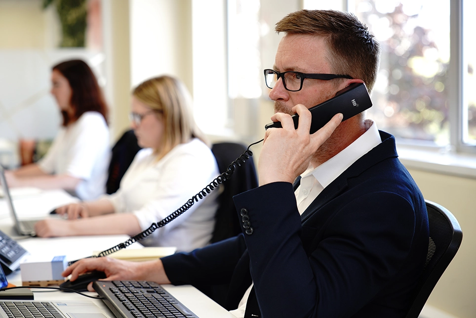 IT sales engineer at a desk on the phone to a customer in the South West