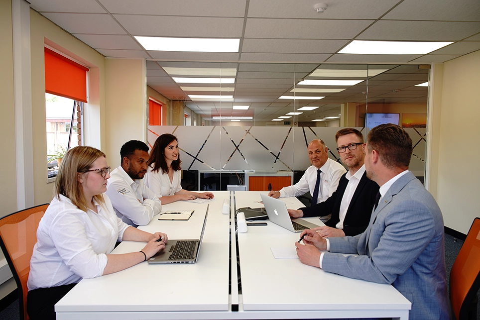 IT sales engineers sat around a meeting table for a team meeting in the Bristol office